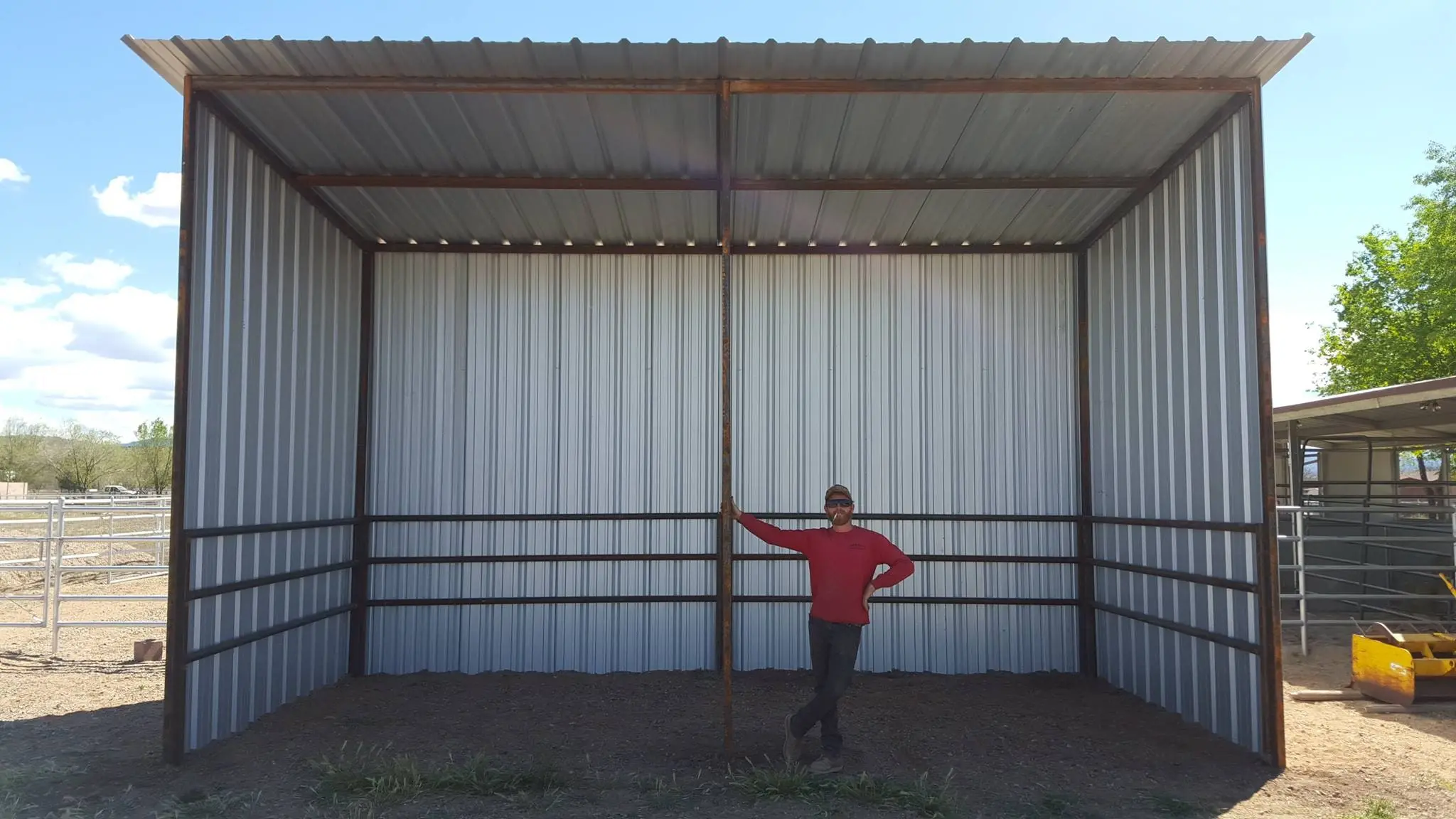 A Corral Kraft crew member standing inside a finished 12-foot steel shade with corrugated walls, showing its height